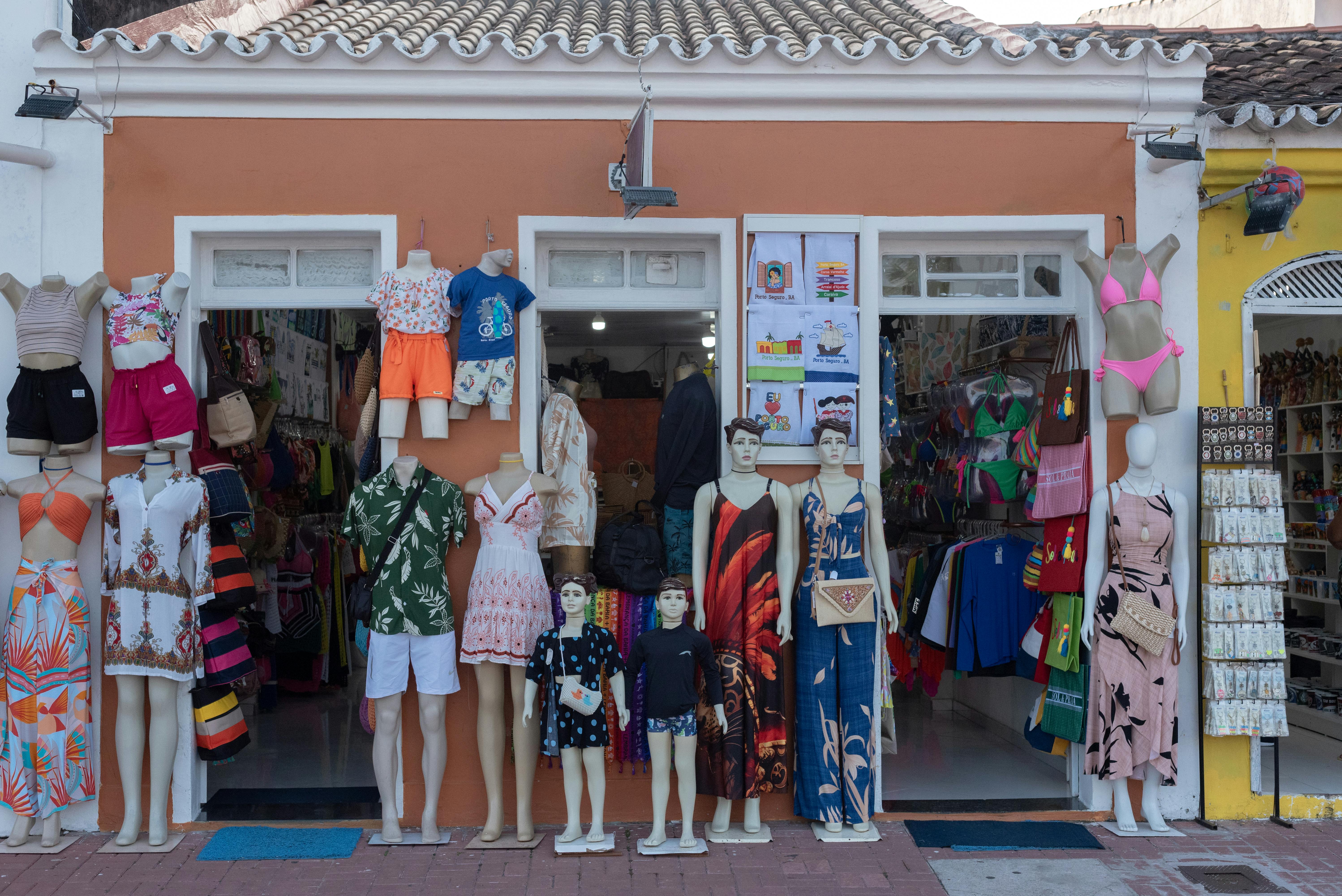 Free Street view of a vibrant clothing store display in Porto Seguro, Brazil featuring mannequins with summer outfits. Stock Photo