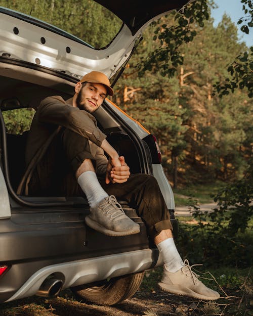 Free Man Sitting On A Hatchback Vehicle Stock Photo