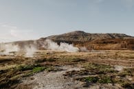 晴朗的天空下，迷人的地热蒸汽从风景如画的山区景观中升起