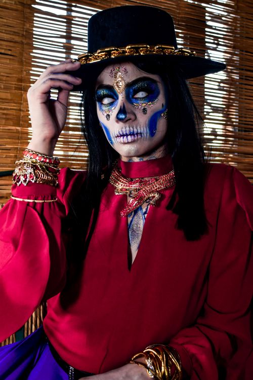 Free Colorful portrait of a person in Día de los Muertos costume with intricate makeup and jewelry. Stock Photo
