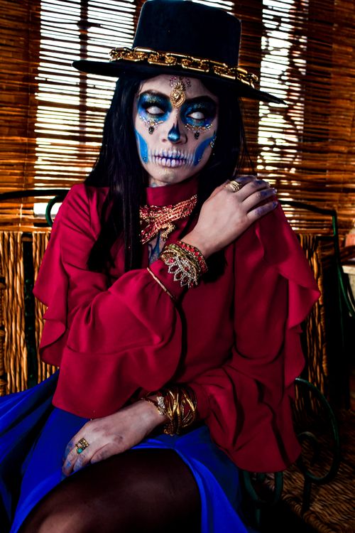 Free Portrait of a woman with vibrant Dia de los Muertos makeup, wearing traditional attire. Stock Photo