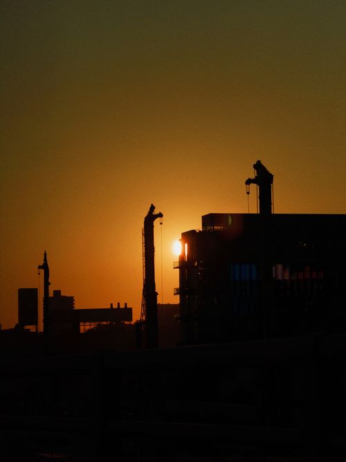 Free Silhouette of Toronto's skyline at sunset, highlighting construction cranes against the vibrant sky. Stock Photo