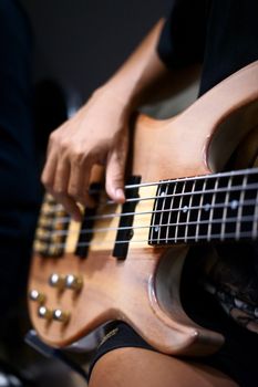 A close-up shot capturing the hands of a musician playing an electric bass guitar.. close, shot, capturing