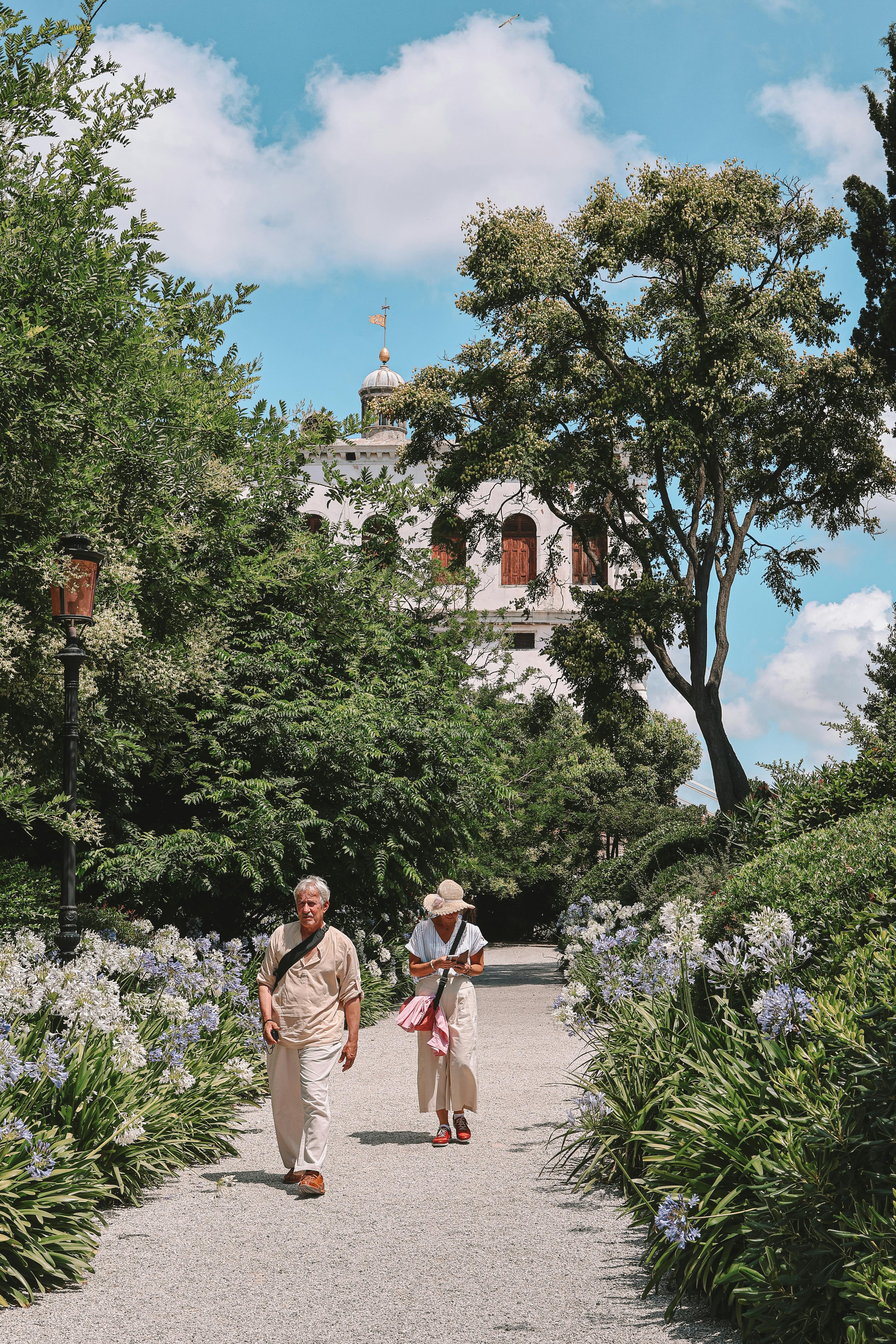 Senior couple walking in a beautiful Venetian garden on a sunny day.