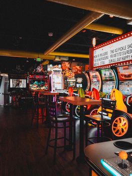 Vibrant indoor arcade filled with colorful game machines and empty seats, inviting entertainment.