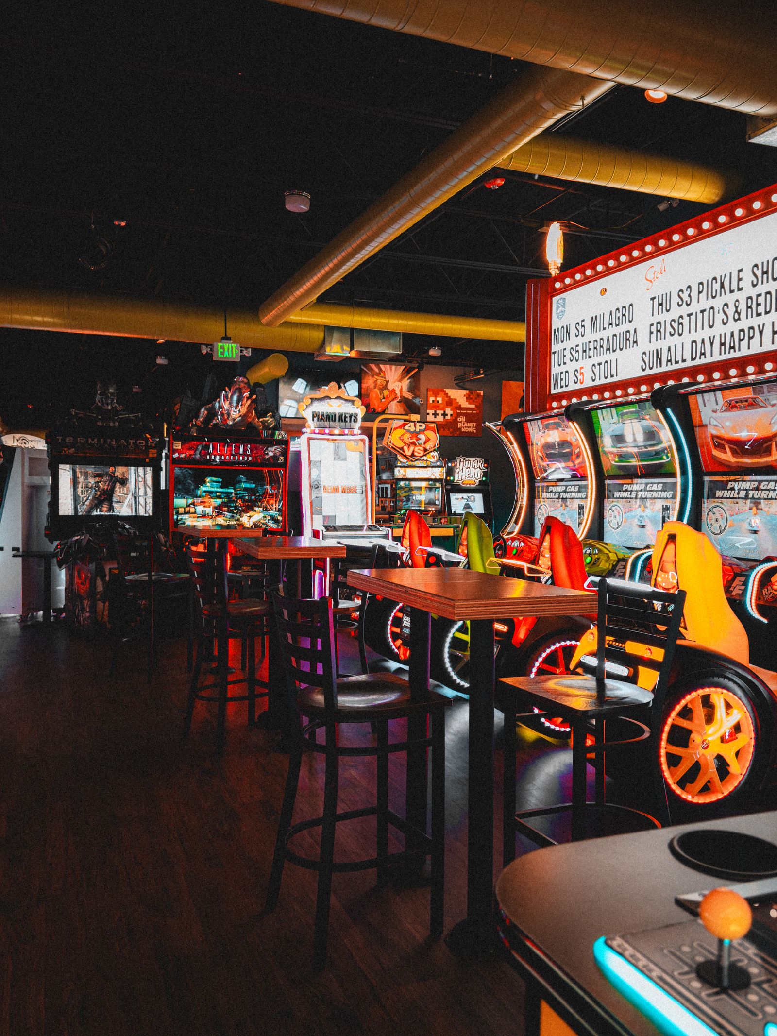 Vibrant Indoor Arcade with Neon Lights and Games · Free Stock Photo