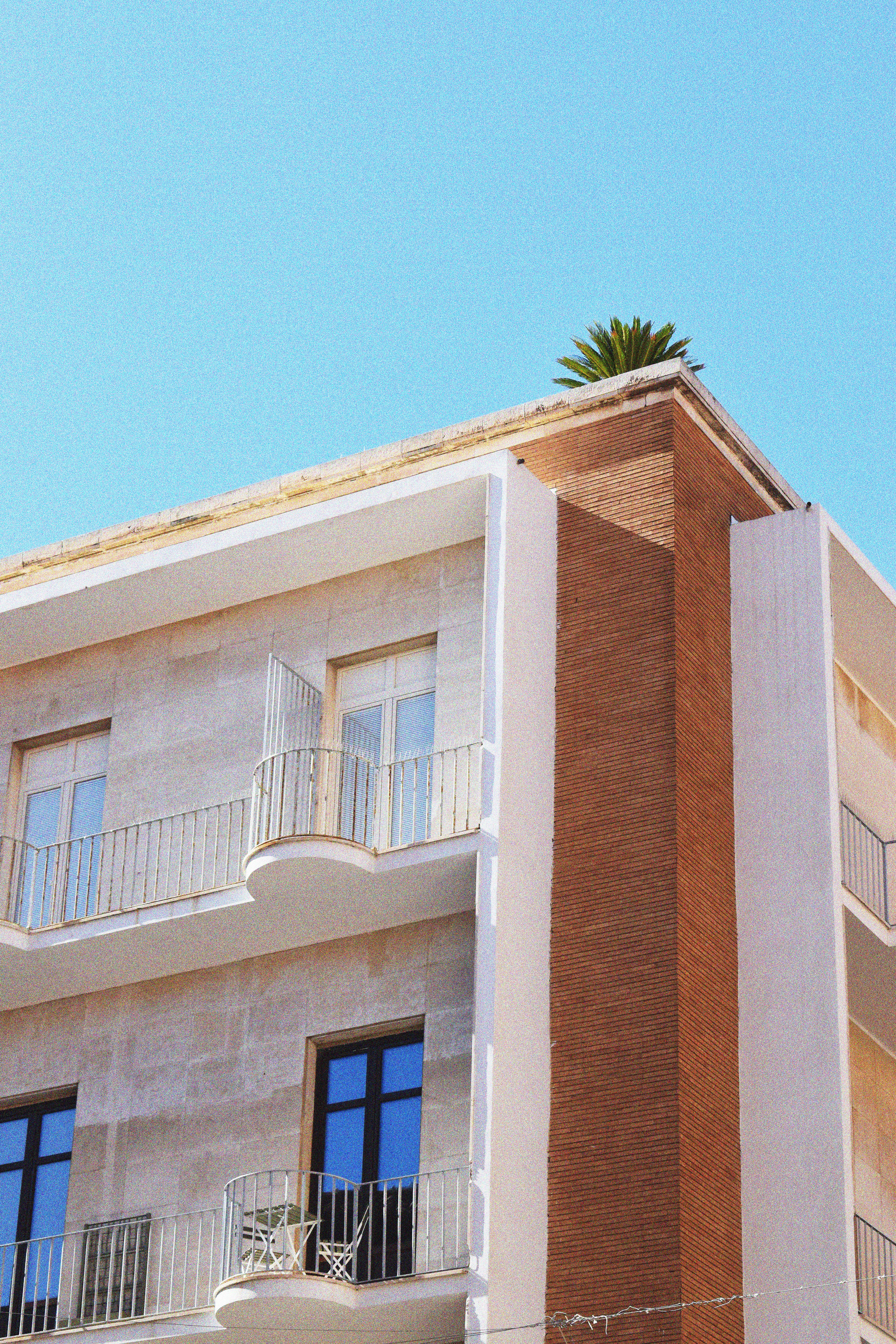 Modern Apartment Building Against Clear Blue Sky · Free Stock Photo