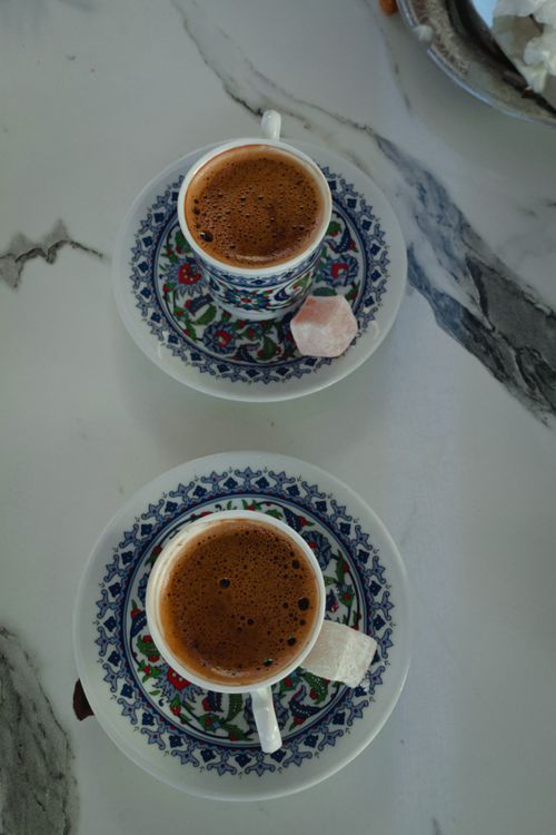 Free Two ornate Turkish coffee cups with sweets on a marble tabletop. Stock Photo