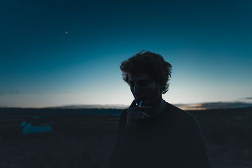 Free A moody silhouette of a man smoking against the twilight sky, outdoors. Stock Photo