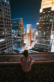 从明尼阿波利斯市中心屋顶俯瞰夜间城市天际线的人