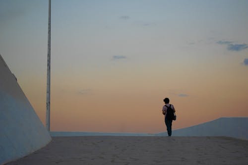 Back View Photo of Person Standing Alone During Golden Hour