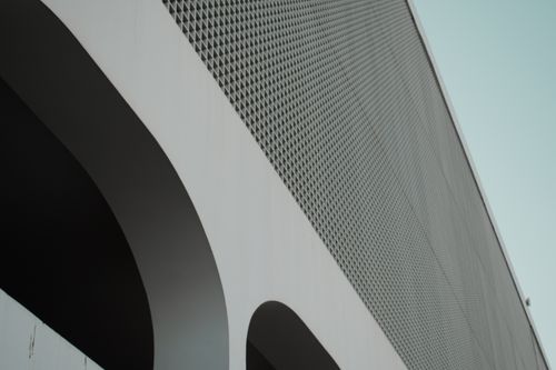 Free Abstract view of a modern building facade featuring intricate geometric patterns and curves. Stock Photo