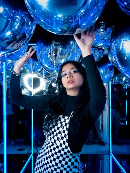 Portrait of a stylish woman at a vibrant party scene with blue reflections, CDMX, Mexico.