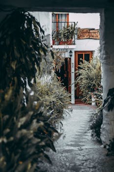 A quaint restaurant entrance surrounded by lush plants, inviting ambiance outdoors.