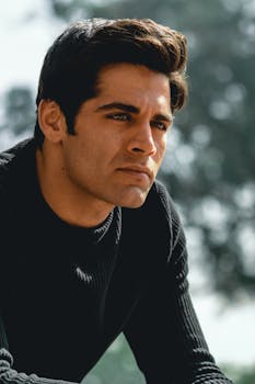 一位严肃男人的户外肖像，在自然光下映出倒影