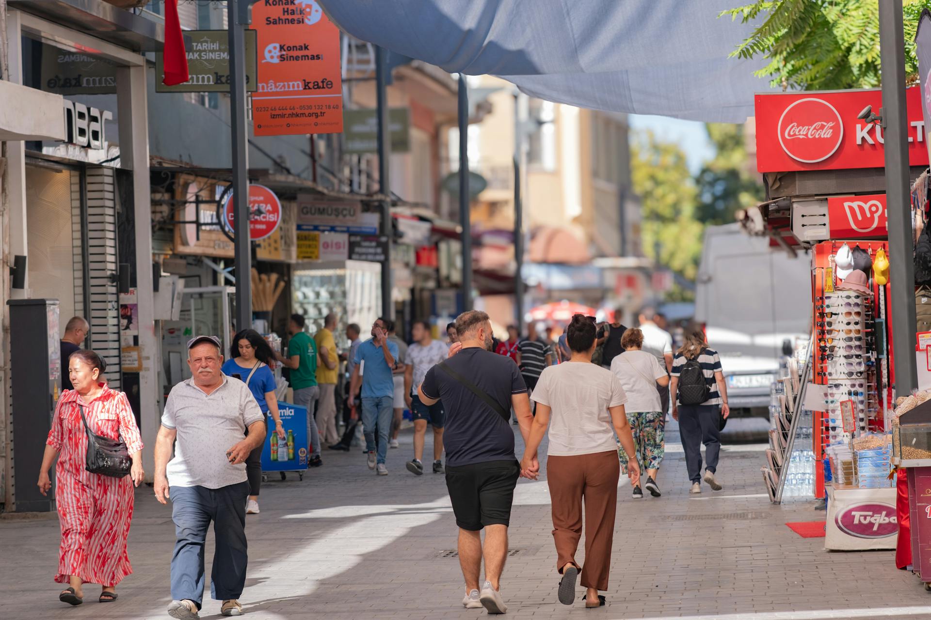 Bustling daytime scene at Kemeraltı Bazaar, İzmir, showcasing diverse people and shops.