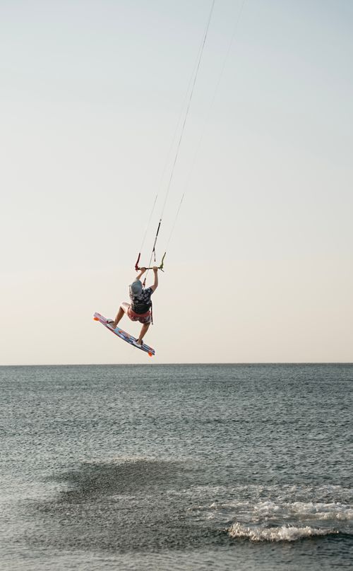 Free Dynamic kiteboarder executing a jump over the Aegean Sea in Gökçeada, Turkey. Stock Photo