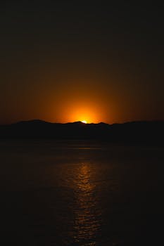 Captivating sunset casting warm hues over tranquil ocean waters.