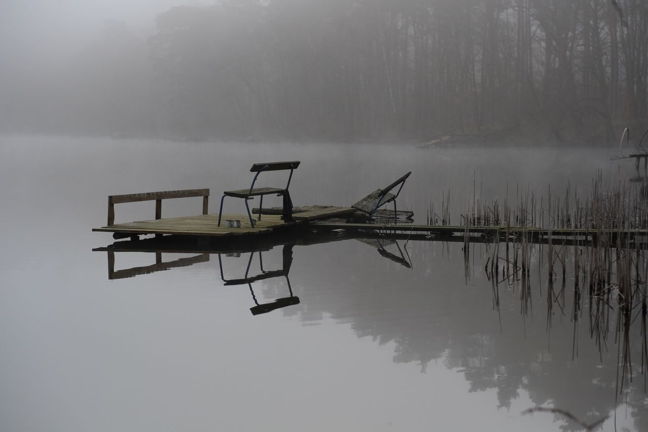 calm pier on a foggy lake with tranquil reflections highlighting seren