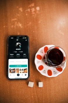 Overhead shot of a smartphone and traditional tea, creating a modern-meets-classic scene.