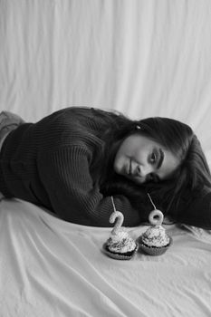 Black and white photo of a woman celebrating a birthday with cupcakes.