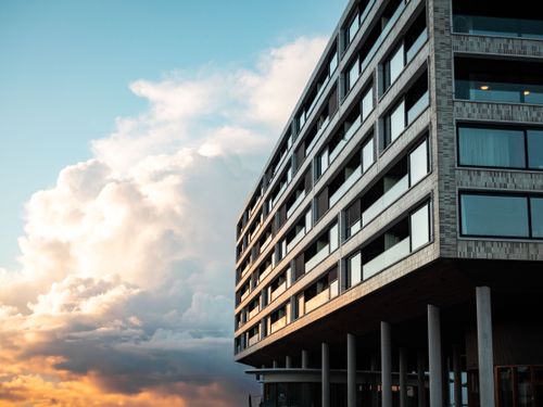 Free Contemporary multi-story building against a stunning sunset sky. Stock Photo