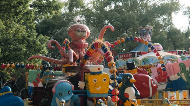 Vibrant carousel ride featuring playful octopus and cartoon figures in a park setting.