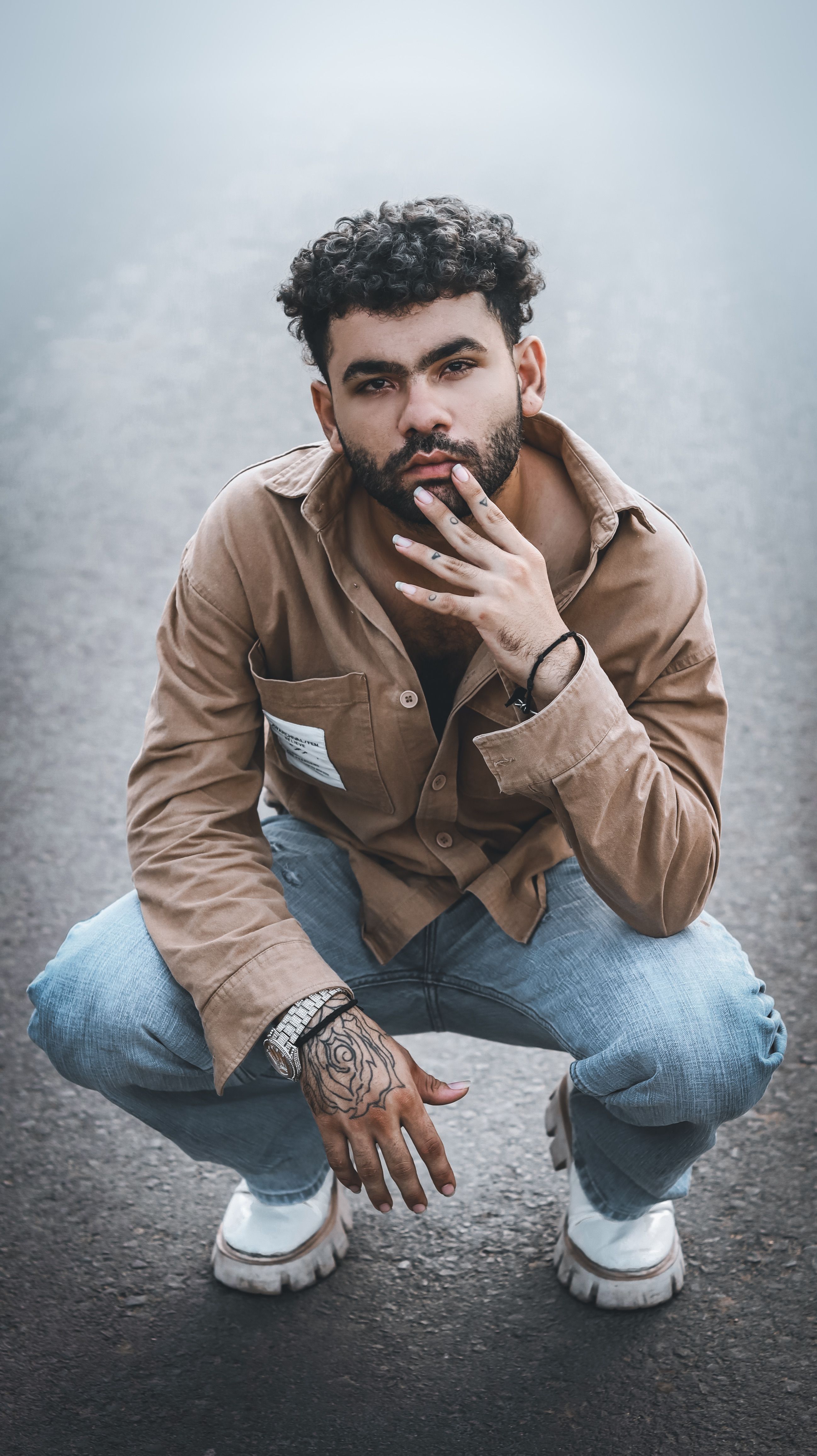 Man in casual attire posing confidently on a road.
