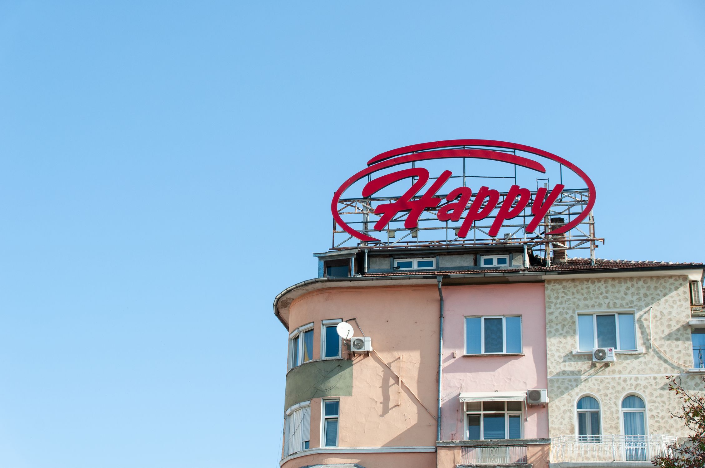 Hapopy Building Happy Sign on Colorful Building Rooftop · Free Stock Photo