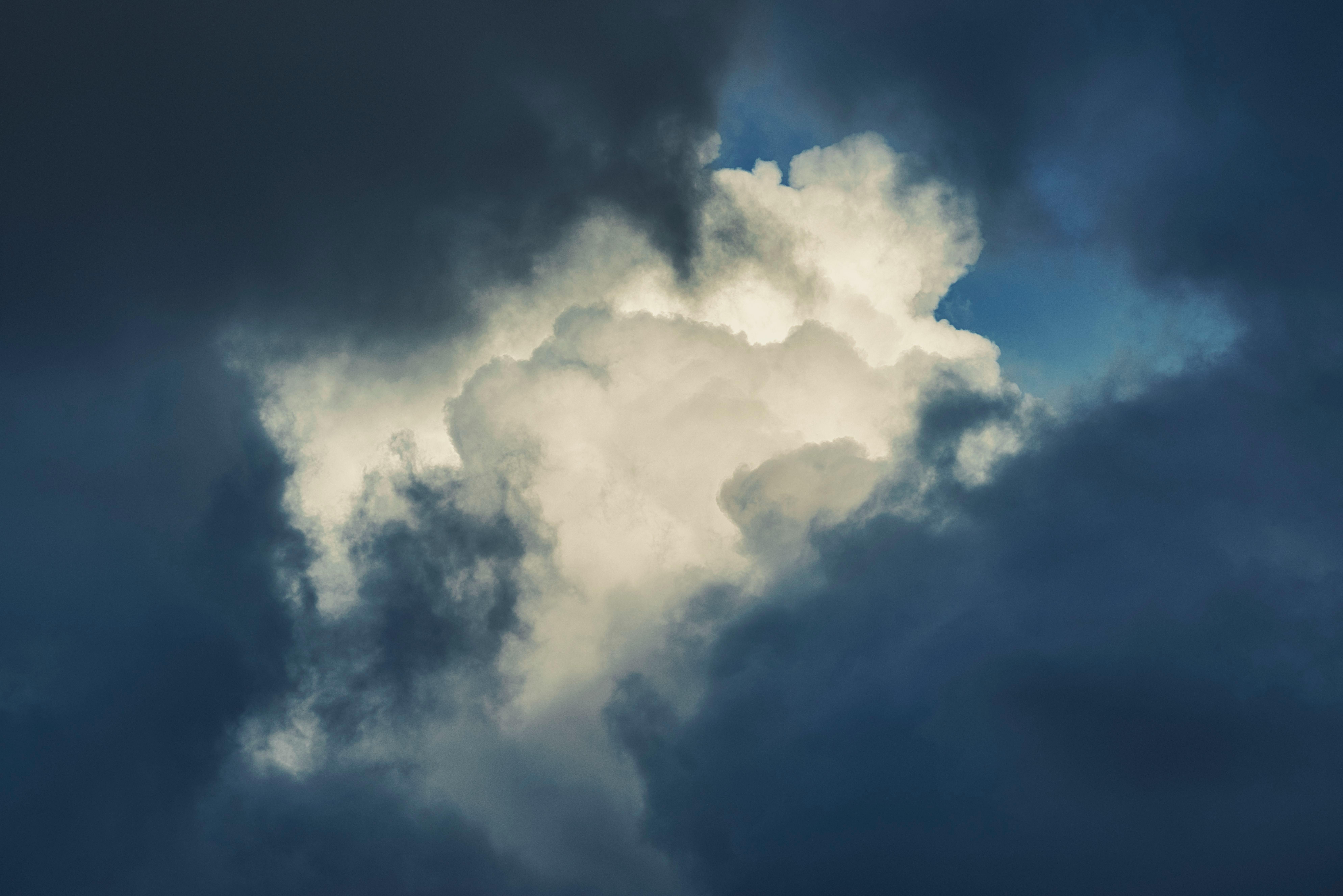 A dramatic cloud formation with sunlight breaking through, creating a striking contrast in the sky.