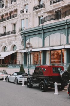 High-end cars parked outside an elegant historical hotel, showcasing luxury lifestyle.