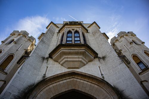 Free Gothic castle facade against a clear blue sky, showcasing its intricate architecture. Stock Photo