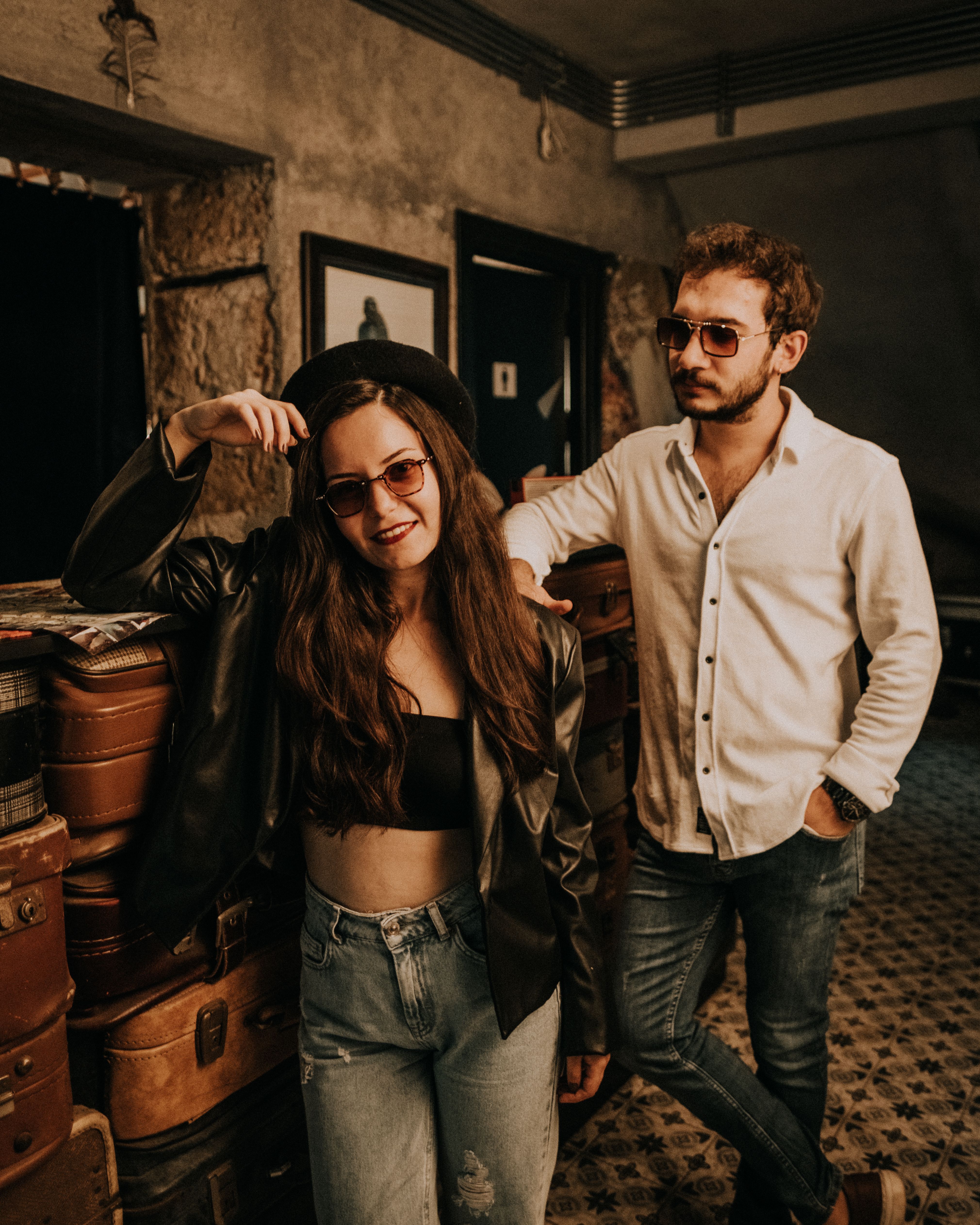 Stylish couple poses with luggage in a vintage-themed room, exuding retro-chic vibe - historic hotels and inns