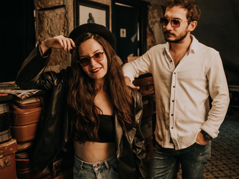 Stylish couple poses with luggage in a vintage-themed room, exuding retro-chic vibe - historic hotels and inns
