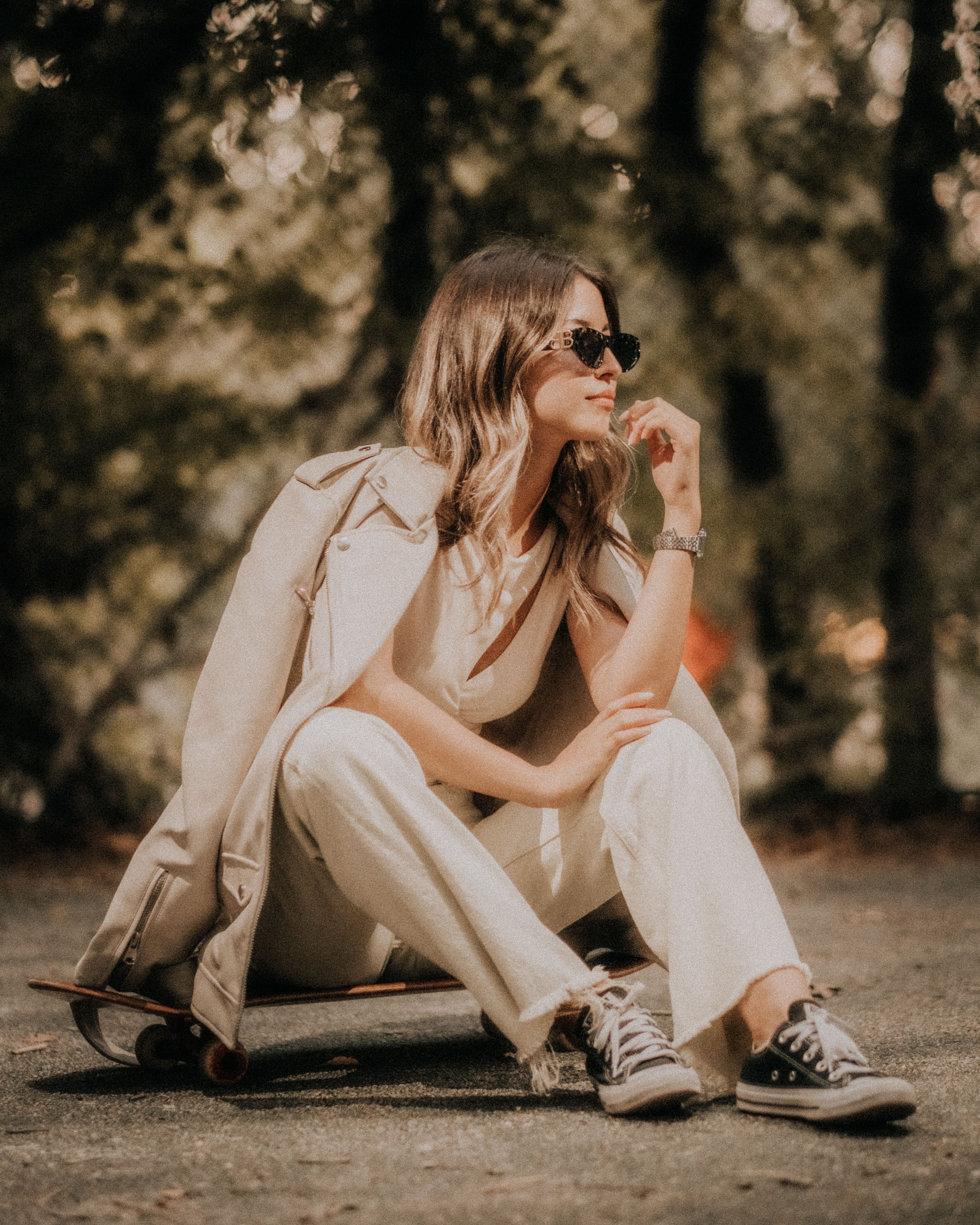 A fashionable woman enjoying a relaxed moment outdoors in Antalya, Türkiye, with a skateboard.