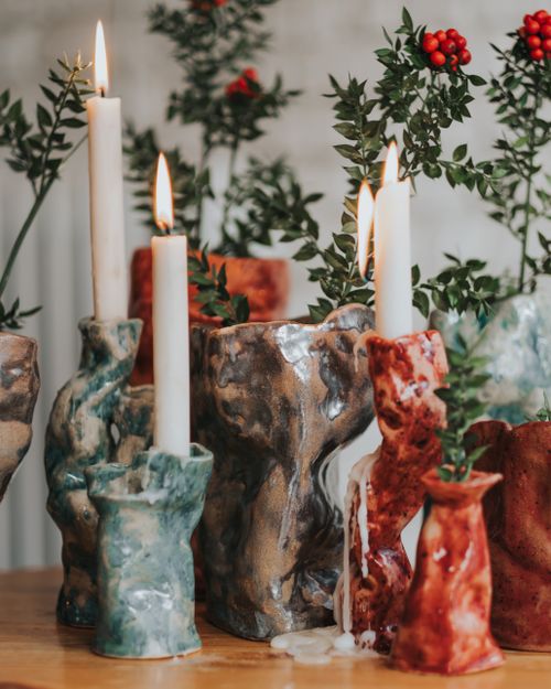 Free Handcrafted ceramic candle holders with candles and fresh greenery. Stock Photo