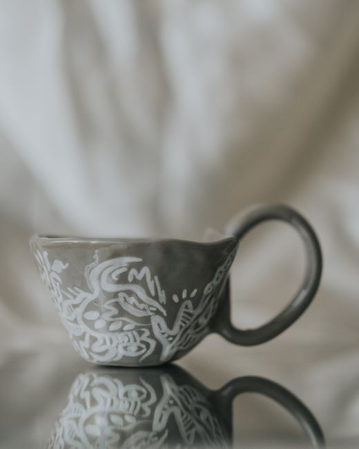 Elegant handcrafted ceramic cup featuring intricate white patterns, reflecting artistry and tradition.