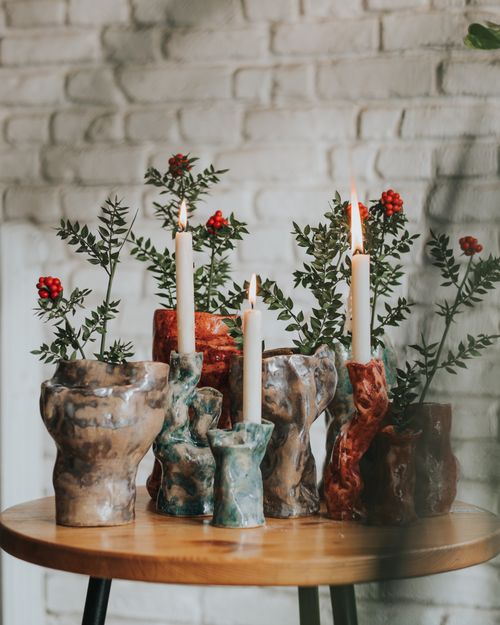 Free Rustic ceramic candle holders with greenery on a wooden table, perfect for home decor. Stock Photo