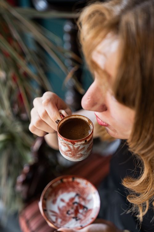 Free A woman savoring authentic Turkish coffee in a beautifully designed cup indoors. Stock Photo