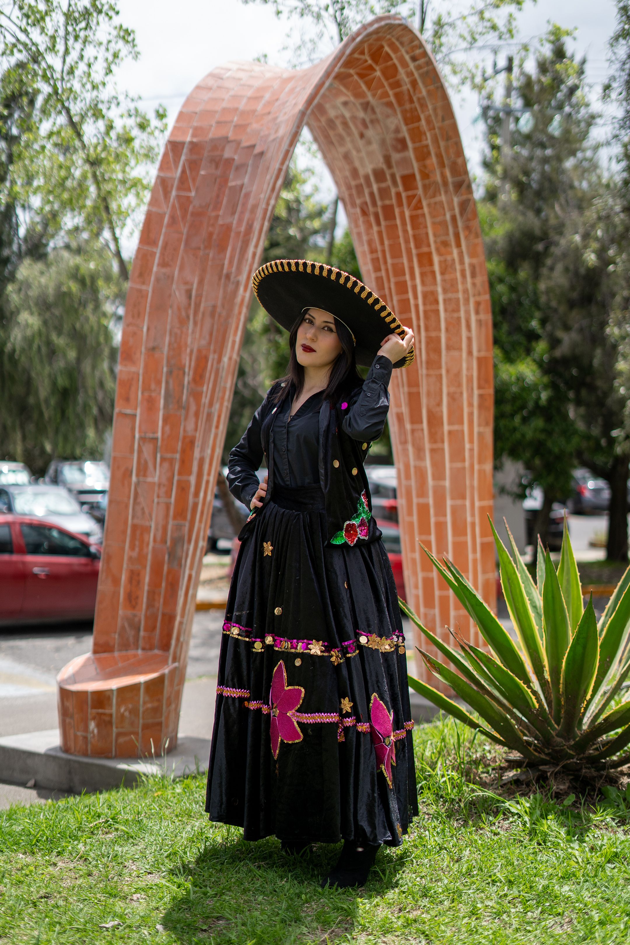 Woman in Traditional Dress Standing by Modern Arch  Free Stock Photo