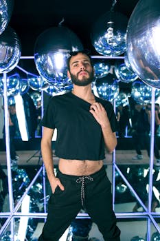 Stylish man in a mirrored room surrounded by reflective spheres in Ciudad de México, creating a disco vibe.