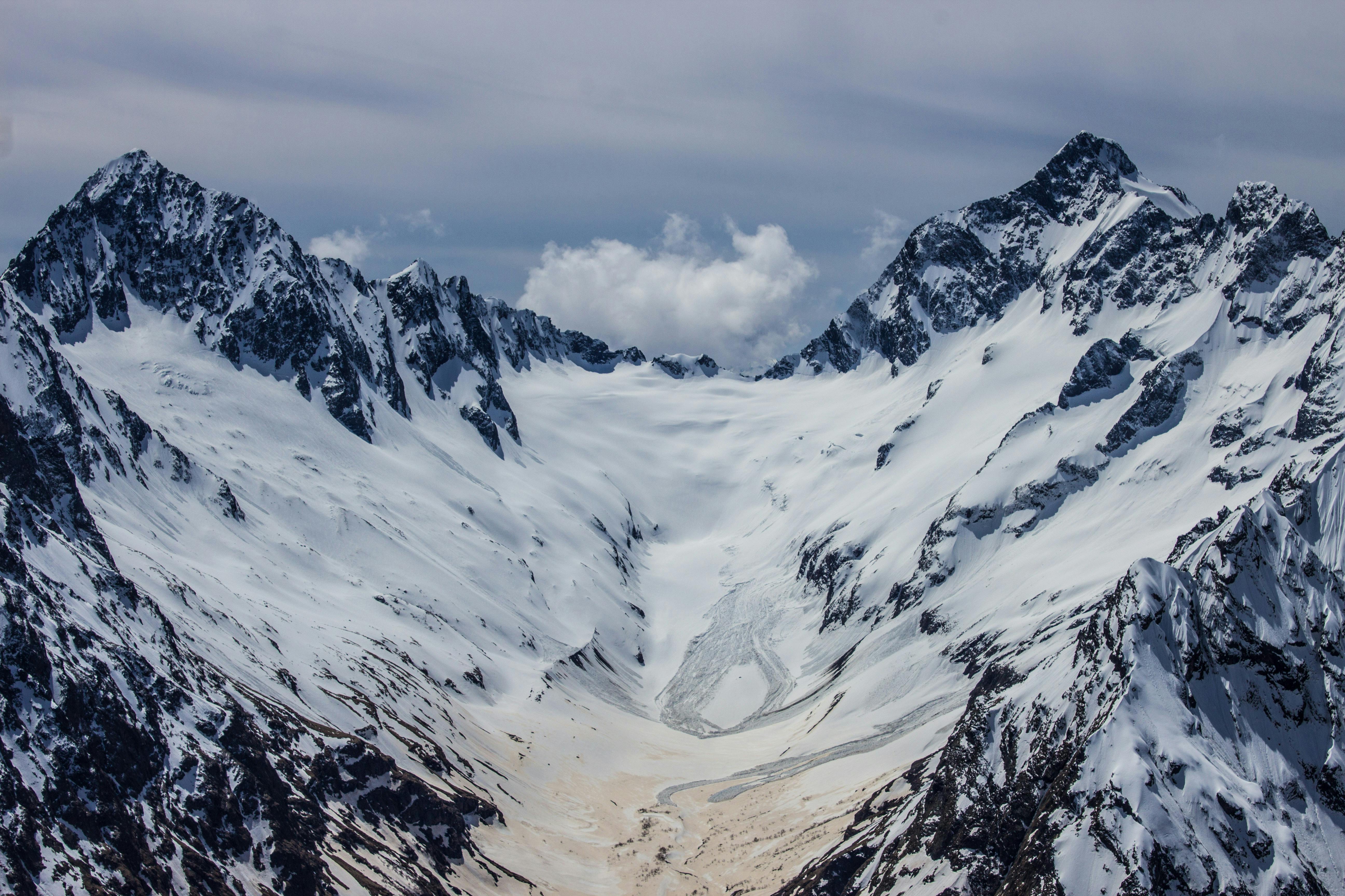 Prescription Goggle Inserts - Stunning view of pristine snow-covered mountains under a cloudy sky, showcasing natural beauty.