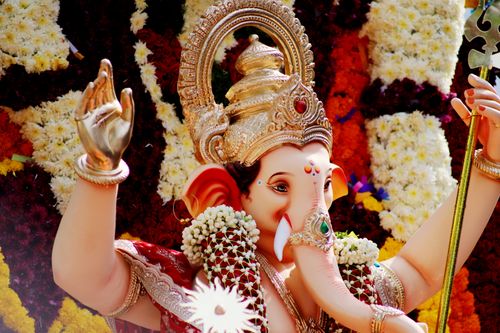 Free Beautiful image of Lord Ganesha statue adorned with vivid flowers and intricate ornaments. Stock Photo