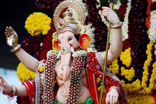 Free Colorful Ganesh statue adorned with flowers and intricate jewelry. Stock Photo