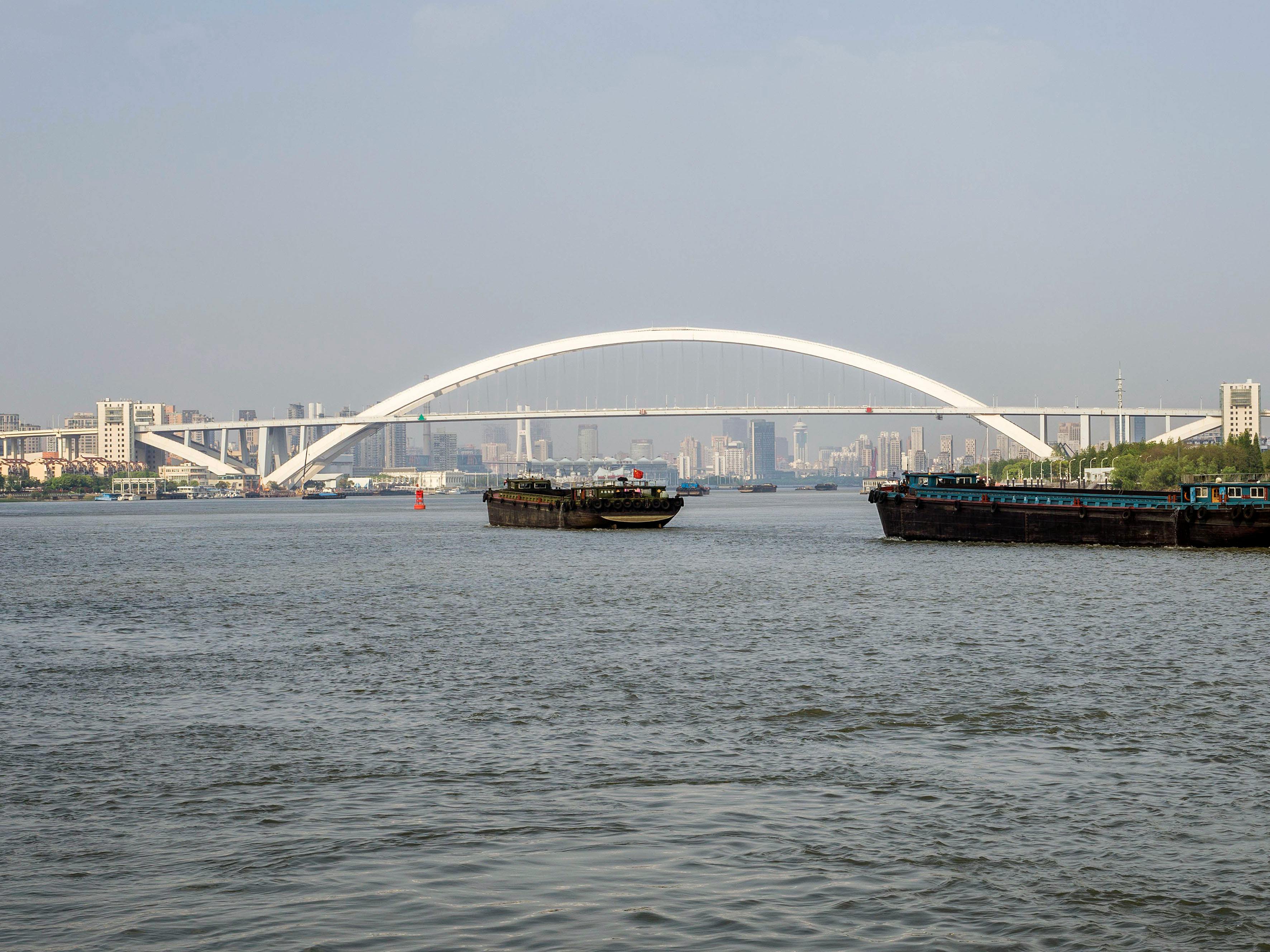 Breathtaking view of Lupu Bridge with ships on the Huangpu River in Shanghai, China.