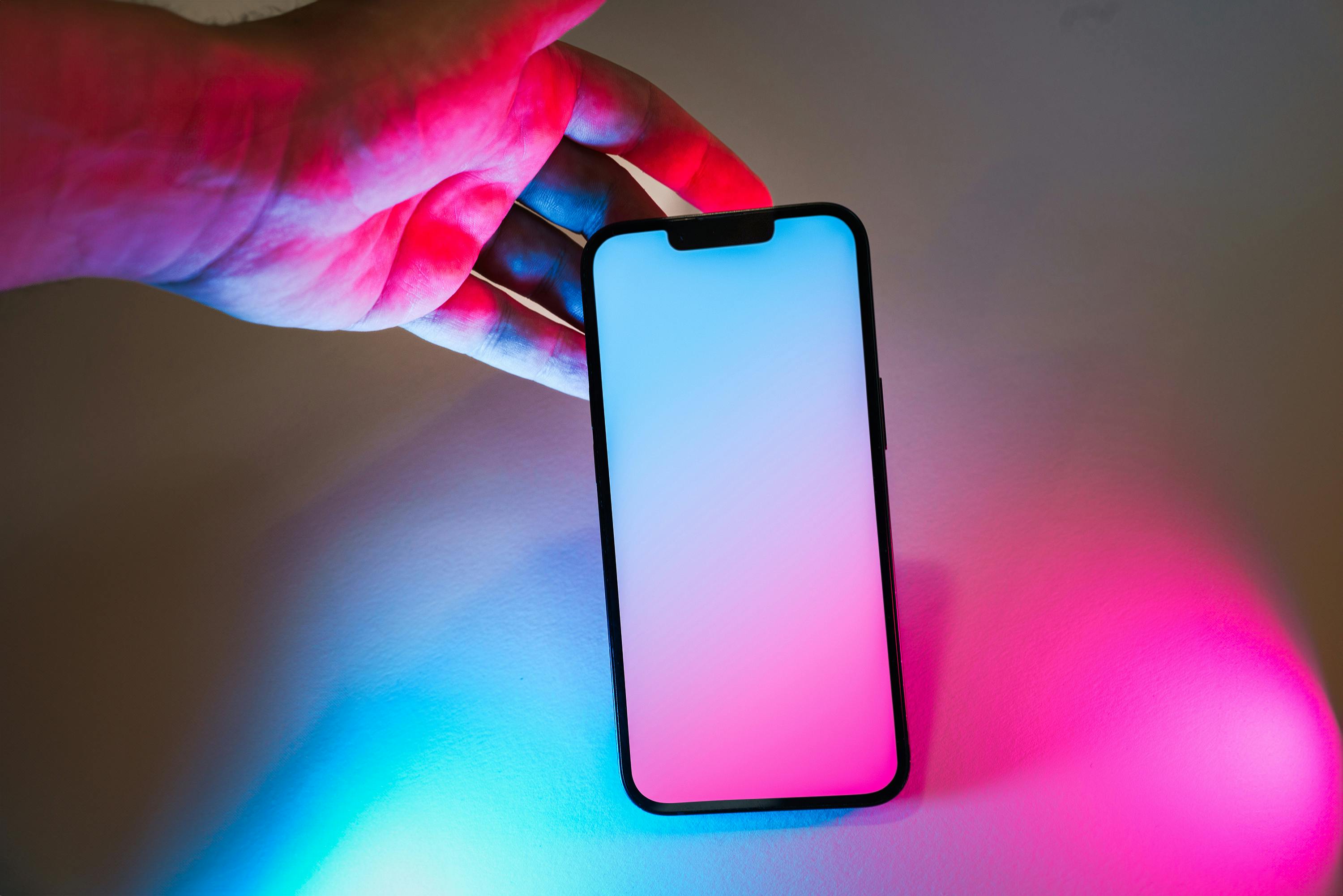 Smartphone with neon pink and blue glow, offering ample copy space for design mockups.