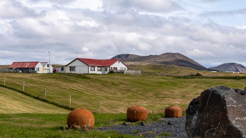 무료 산 근처 농지로 둘러싸인 흰색과 갈색 집 스톡 사진