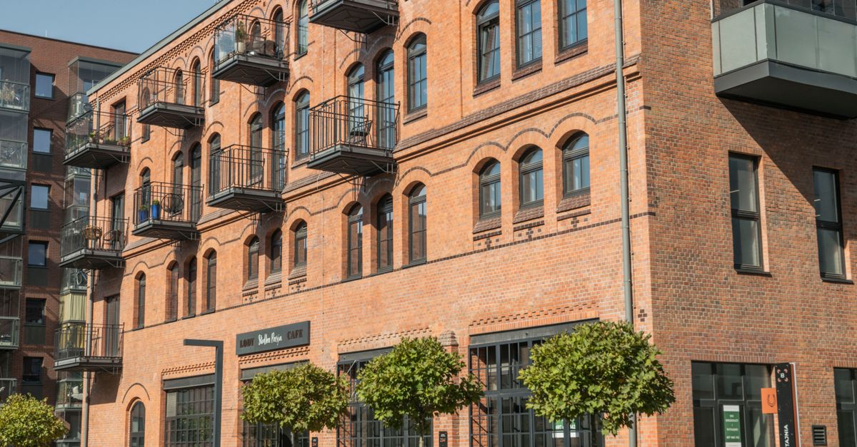 A historic brick building with balconies in Wrocław, showcasing unique architecture and urban charm.