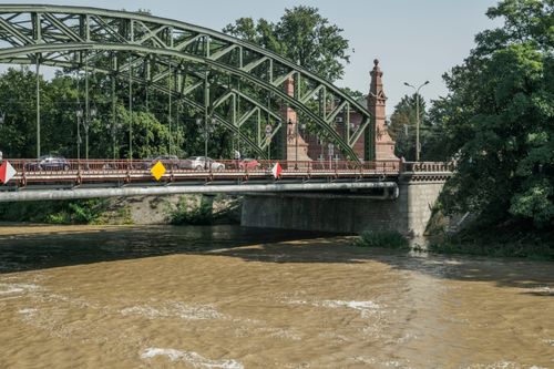Free Tumski Bridge spanning the Odra River in Wrocław, surrounded by lush greenery on a summer day. Stock Photo