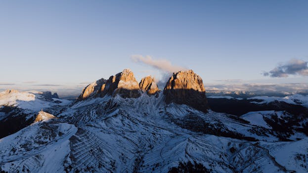 Breathtaking aerial view of the Dolomites in Canazei, Italy during sunset in winter.